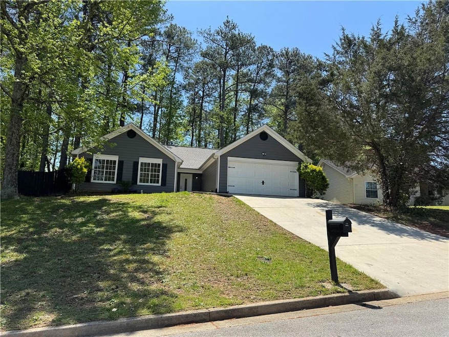 Single story home featuring a garage, a front yard
