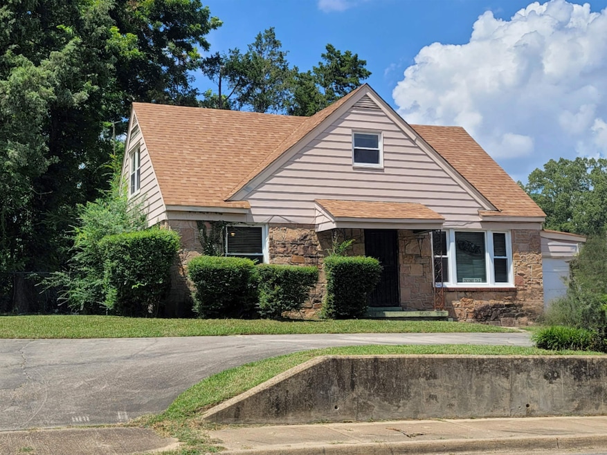 Bungalow-style home with stone siding and roof with shingles