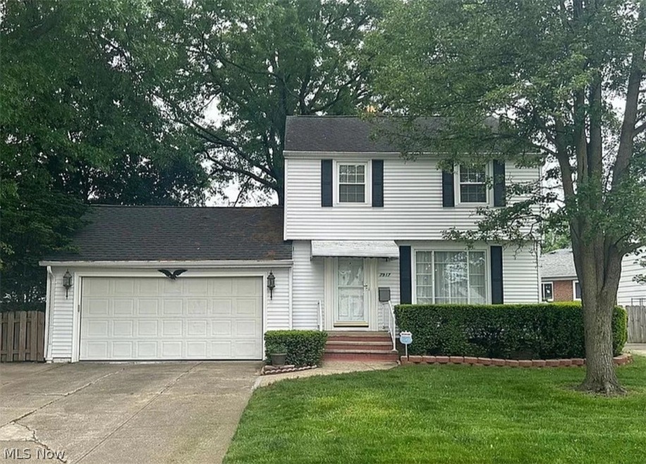 View of front of home with a garage and a front yard