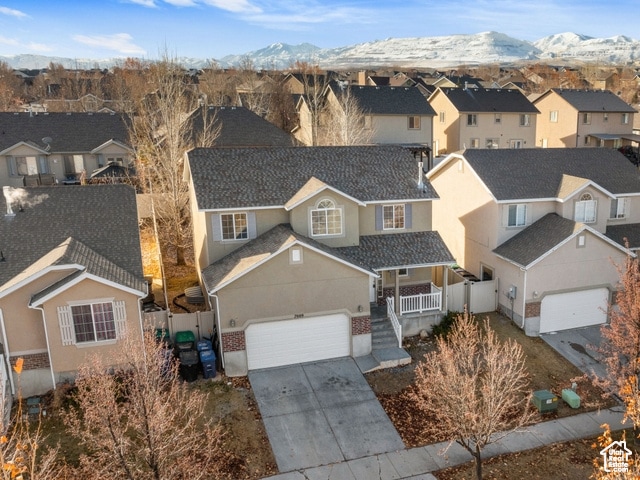 View of front of house featuring covered porch, stucco siding, a mountain view, and driveway