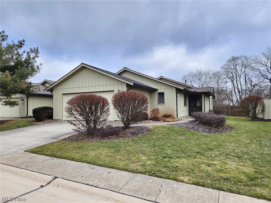 Ranch-style house featuring a front yard and a garage