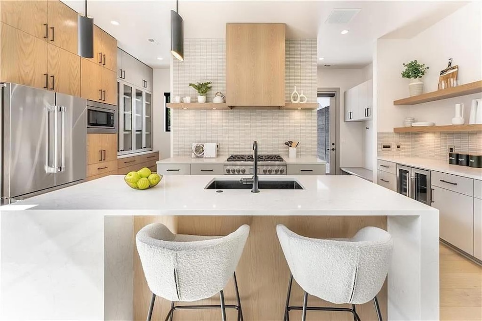 Luxury chef's kitchen with ample storage, custom cabinetry, stainless appliances and a built-in beverage bar!