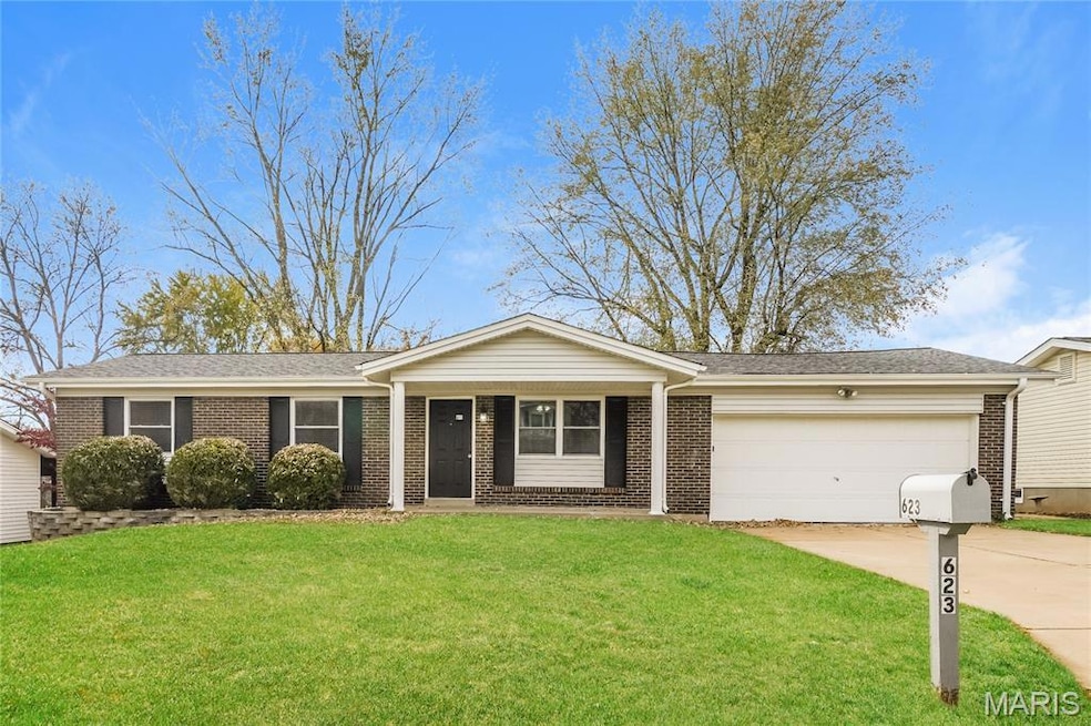 Ranch-style home with covered porch, a front yard, concrete driveway, brick siding, and an attached garage