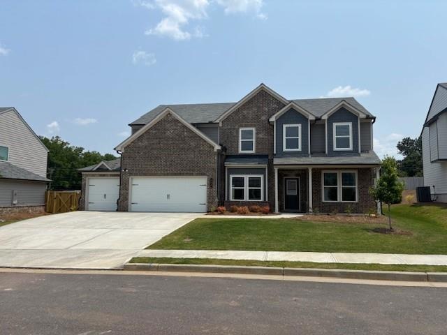 View of front facade with brick siding, driveway, an attached garage, and cooling unit