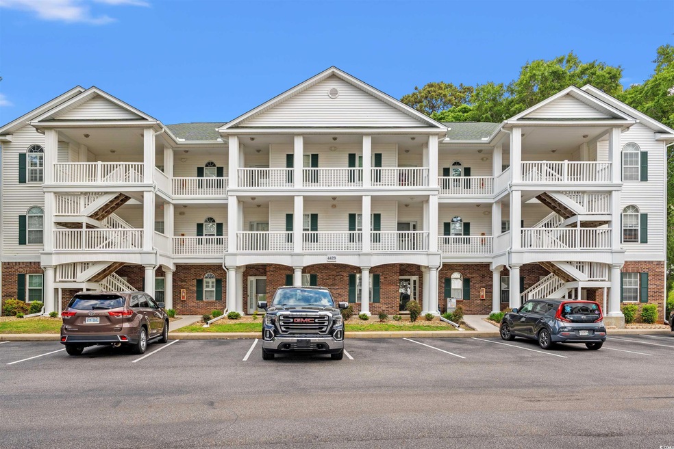 View of building exterior with uncovered parking a