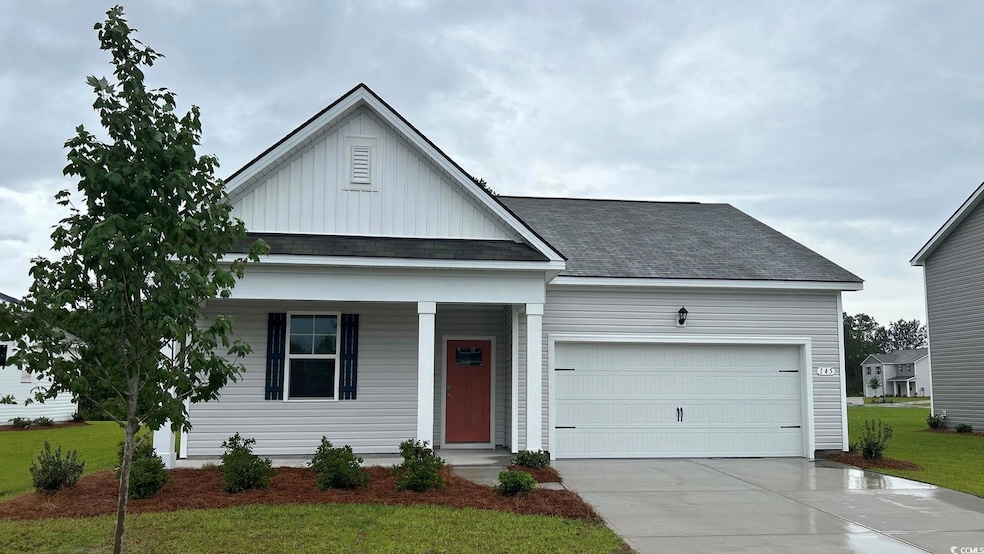 View of front of home with board and batten siding, covered porch, driveway, roof with shingles, and a front yard
