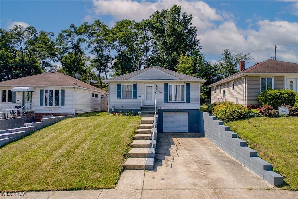 Bungalow featuring a front lawn, concrete driveway, and a garage