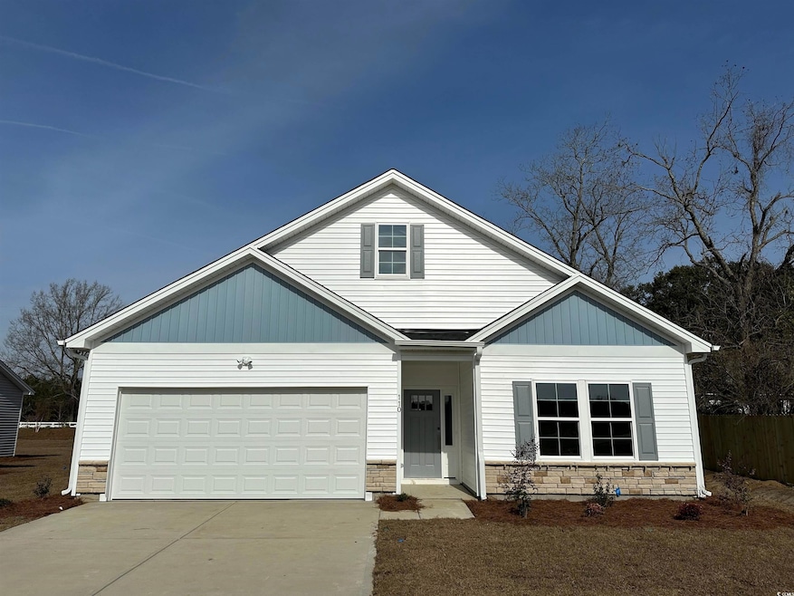 View of front of home featuring a garage, stone si