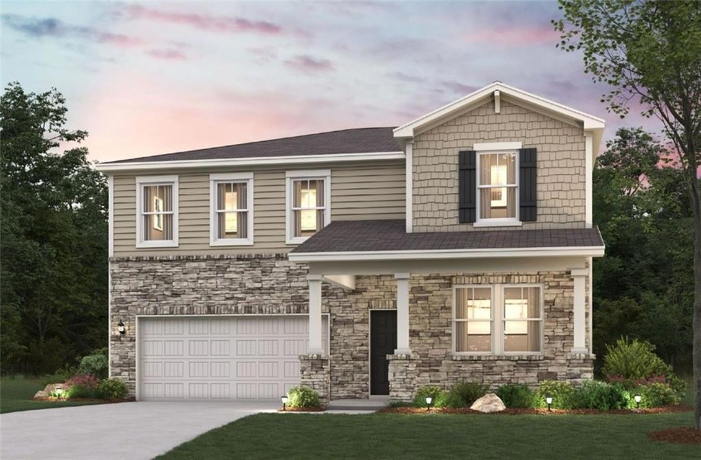 View of front of home with a garage and a yard