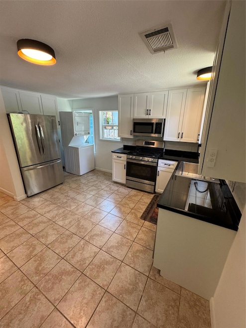 Kitchen with stove, refrigerator, washer / dryer,