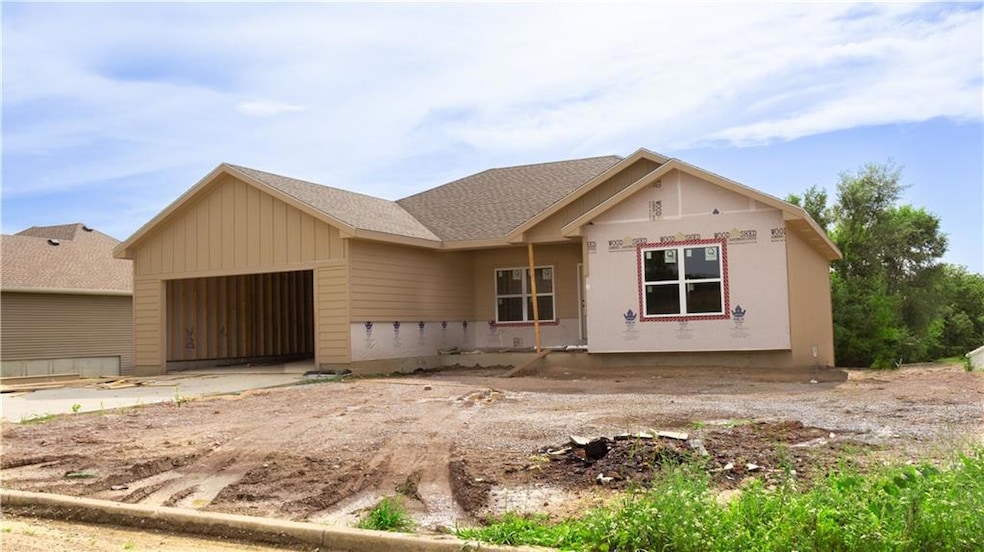 Unfinished property with an attached garage and roof with shingles