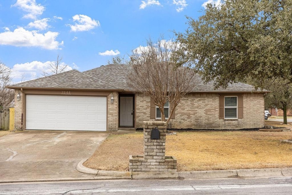 Single story home featuring a garage, brick siding