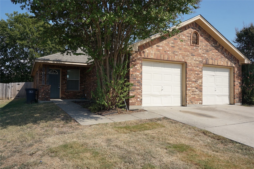 View of front facade with brick siding, a garage, and concrete driveway