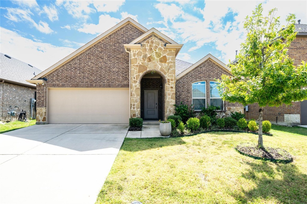 View of front of property featuring a garage and a front lawn