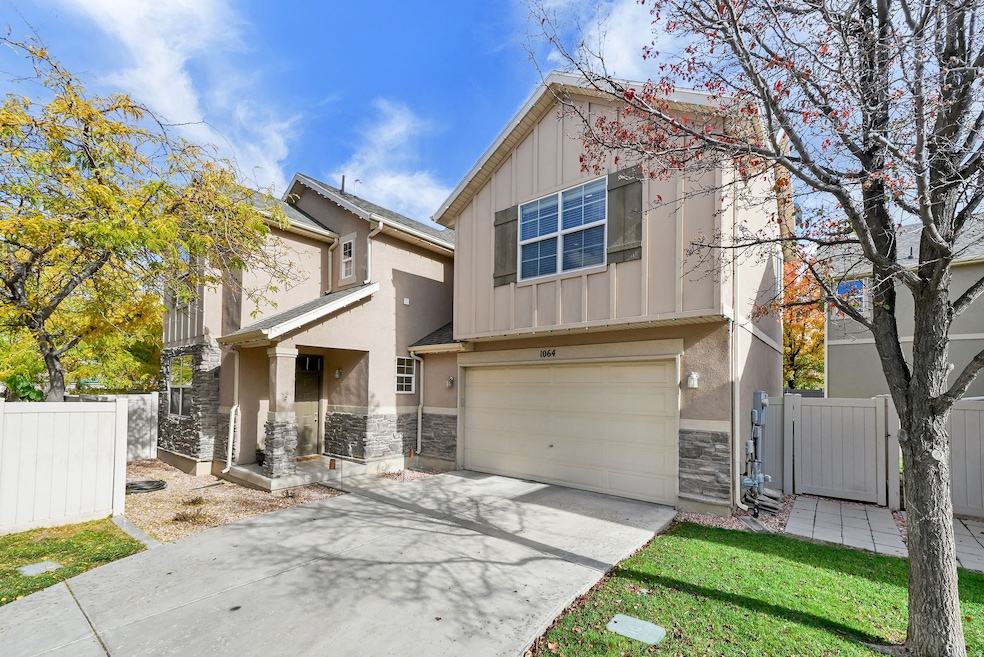 Craftsman-style house with stone siding, board and batten siding, a gate, and an attached garage