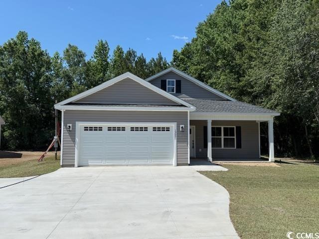 Property in mid-construction with an attached garage and a view of trees