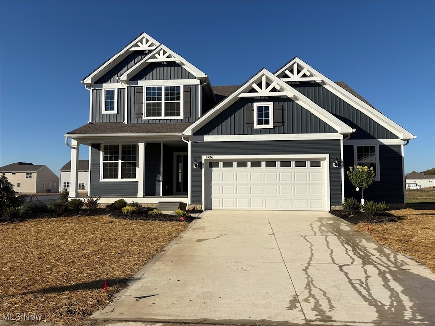 Craftsman-style house featuring a porch, board and batten siding, concrete driveway, and a garage