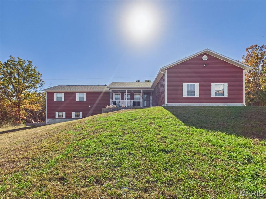 Rear view of house featuring a yard