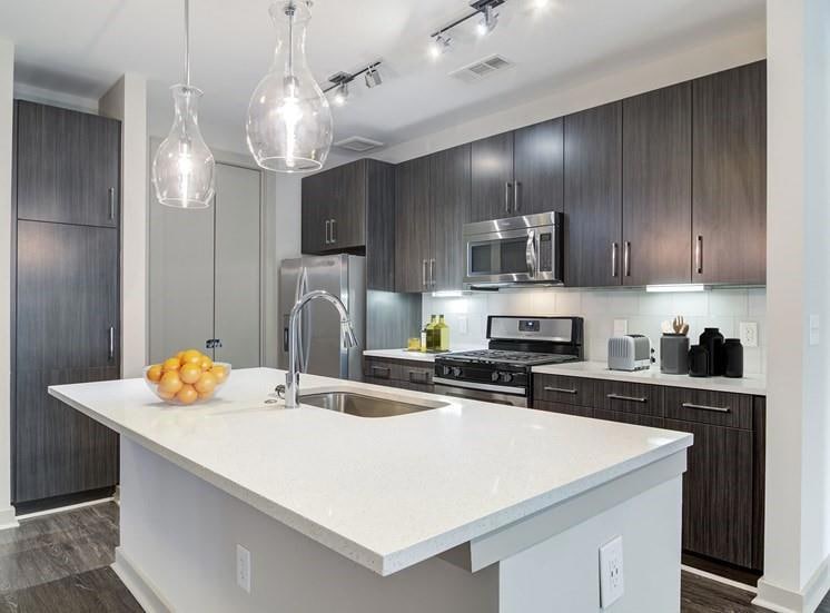 Kitchen featuring a center island with sink, stain