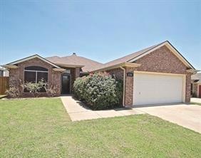 Ranch-style home featuring a front yard and a gara