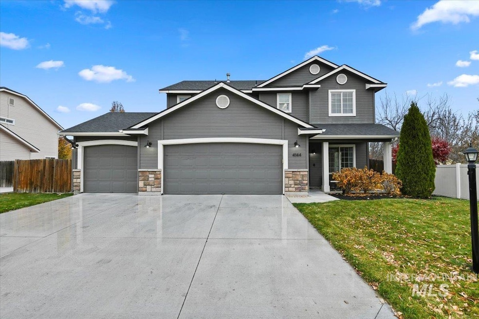 View of front of house with concrete driveway, stone siding, and a garage