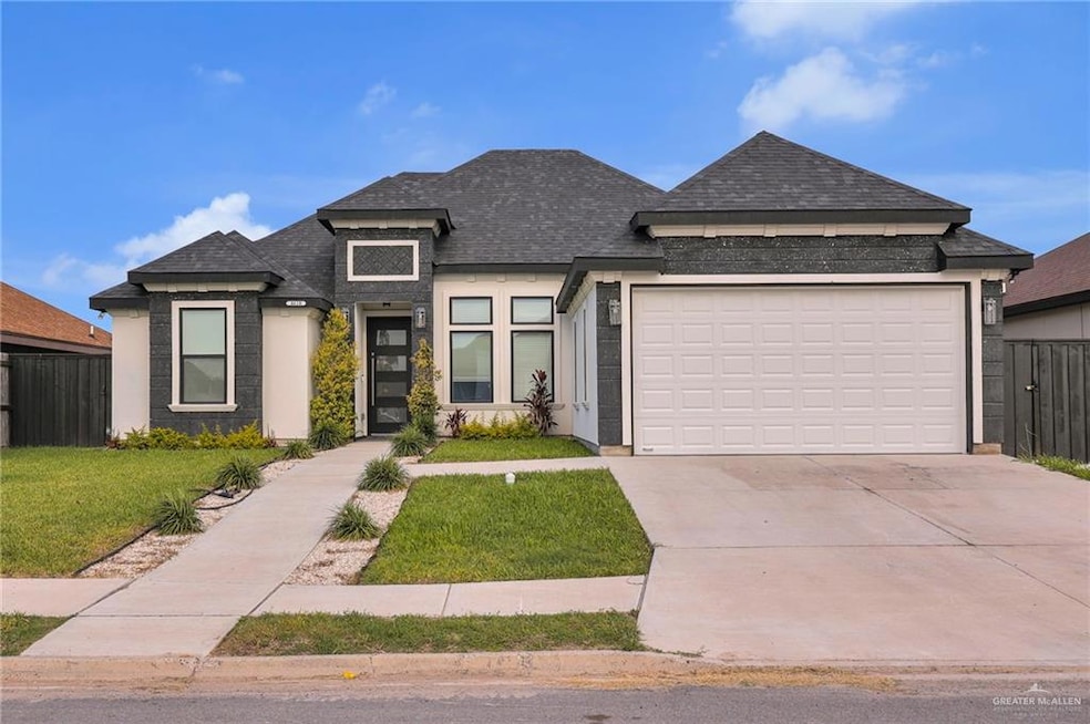 View of front of property with driveway, a shingled roof, and an attached garage