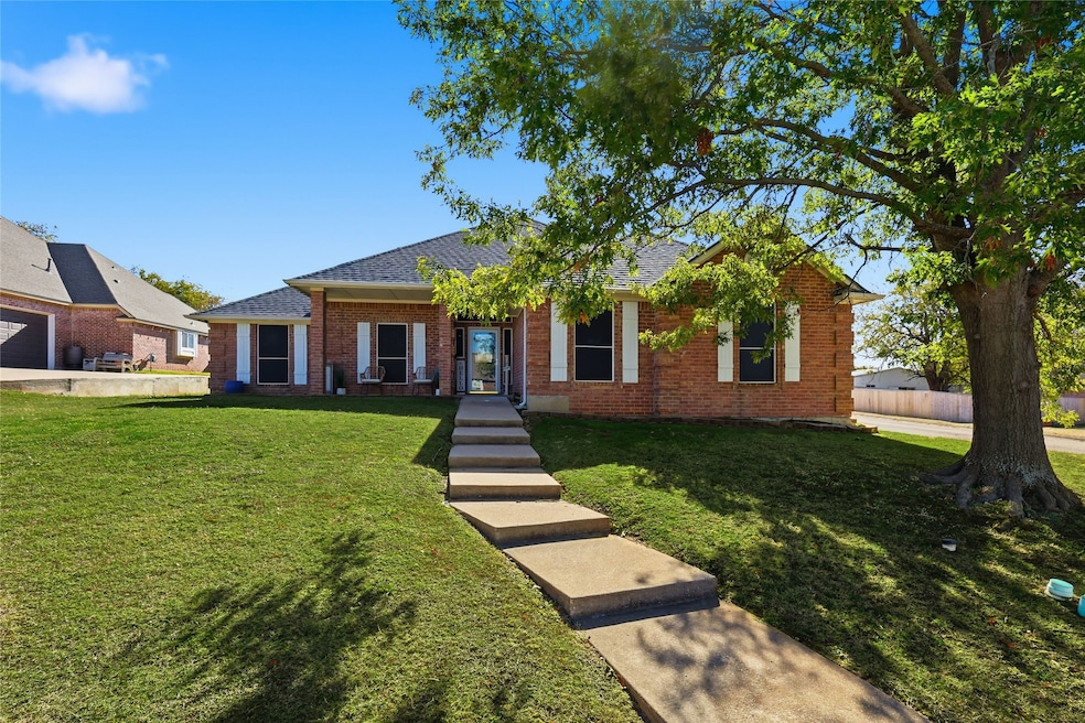 Ranch-style house with a front lawn, brick siding, and a shingled roof