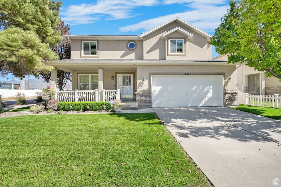 Traditional-style house featuring covered porch, stucco siding, driveway, and an attached garage