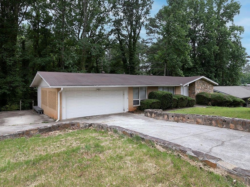 View of front of property featuring a garage, driveway, and a front yard