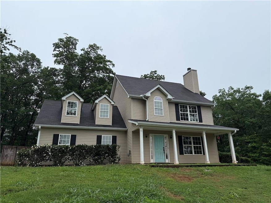 View of front of home featuring a chimney and covered porch