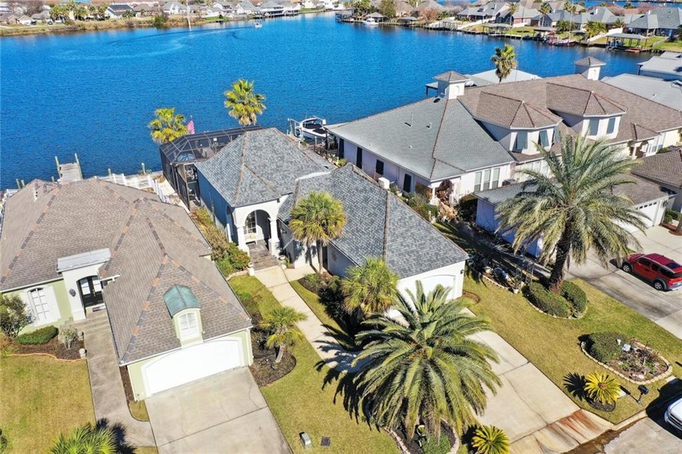 Aerial view of house and lake behind it.
