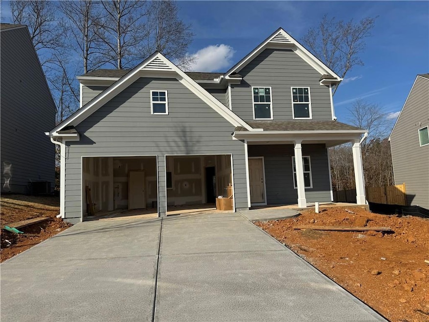 View of front of property featuring driveway and roof with shingles