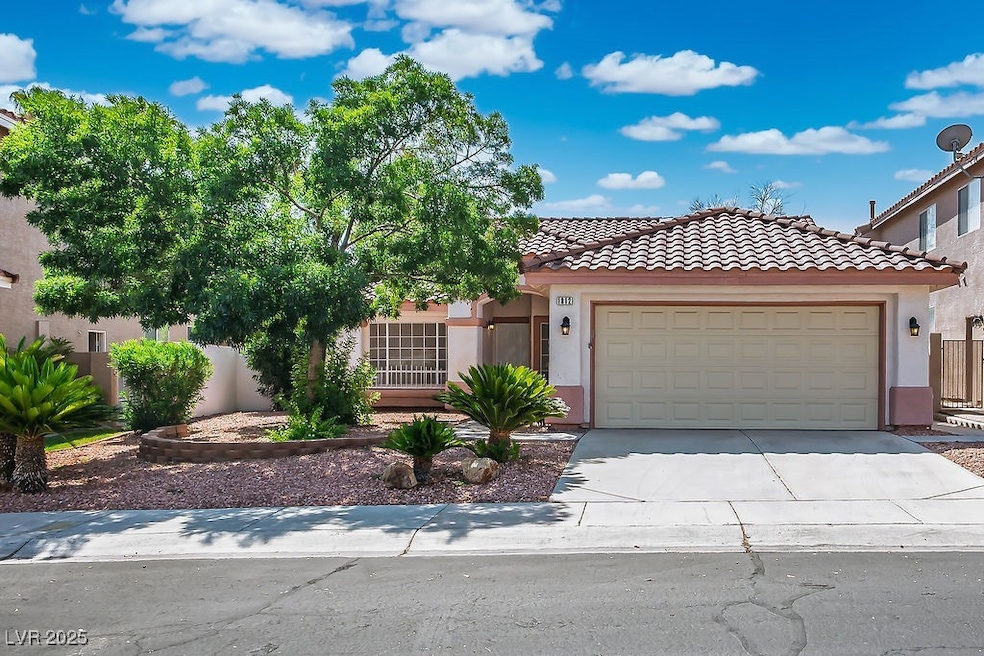 View of front of home featuring stucco siding, a tile roof, concrete driveway, and an attached garage