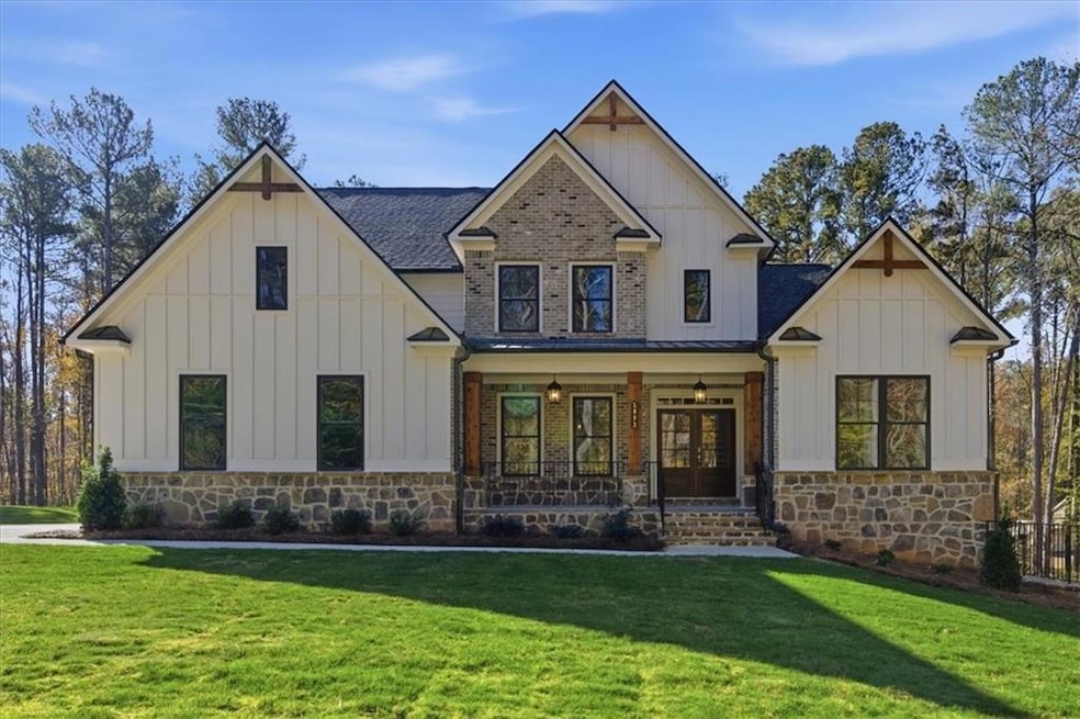 Modern farmhouse with board and batten siding, covered porch, and a front yard