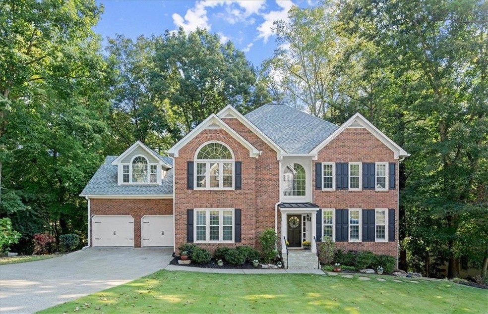 Colonial home featuring a garage and a front lawn