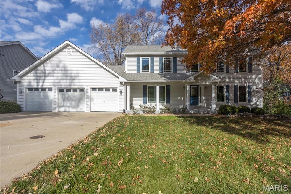 Traditional-style home featuring covered porch, concrete driveway, a front lawn, a garage, and roof with shingles