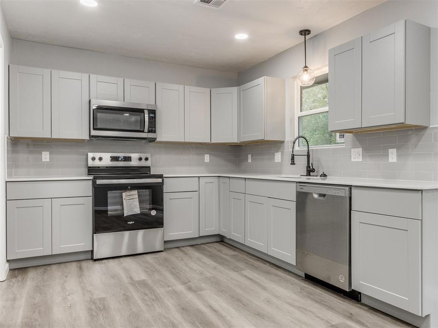 Kitchen with decorative backsplash, appliances wit