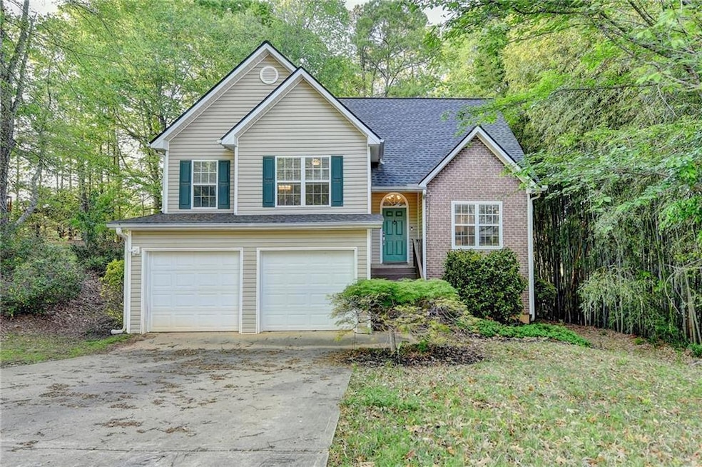Split level home with concrete driveway, brick sid