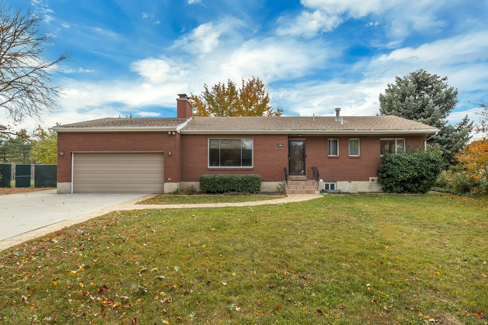 Ranch-style home featuring brick siding, concrete driveway, a front lawn, a chimney, and a garage