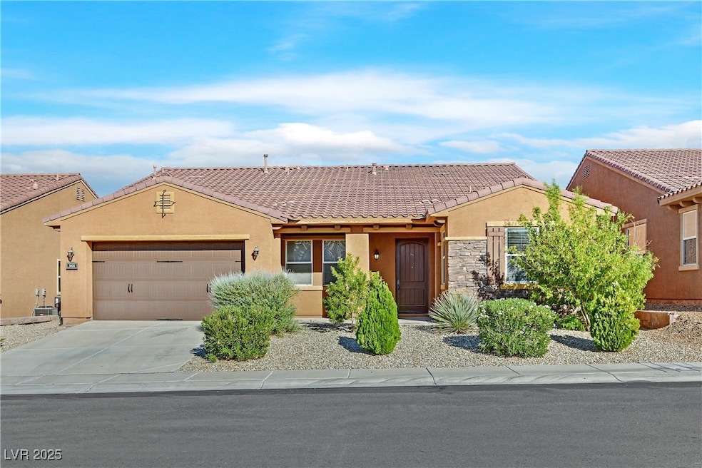 View of front facade featuring stucco siding, driveway, a garage, and stone siding