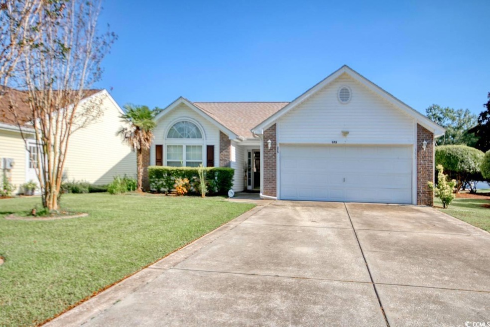 Ranch-style house featuring a front yard and a gar