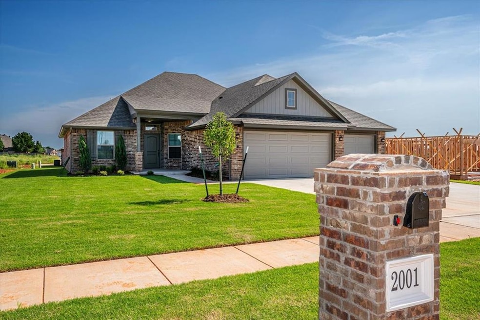 View of front of house featuring a garage, concrete driveway, brick siding, a shingled roof, and board and batten siding
