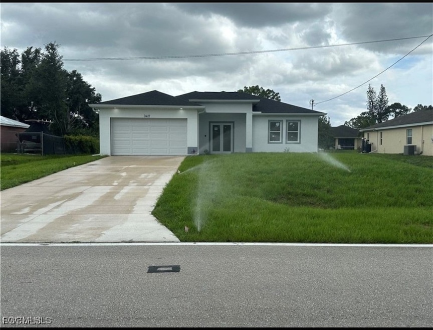View of front facade with a front yard, stucco siding, and driveway