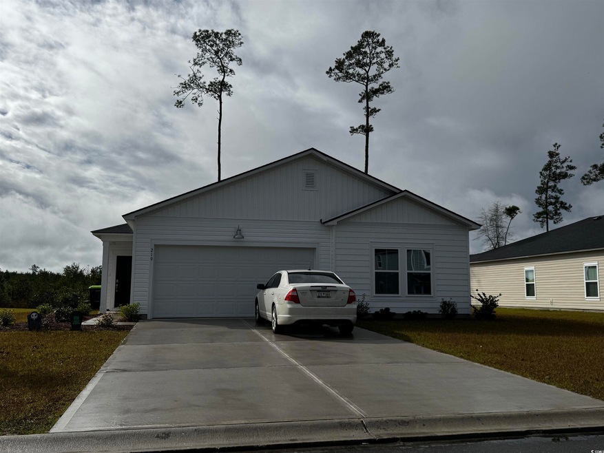 Single story home with a garage and a front lawn