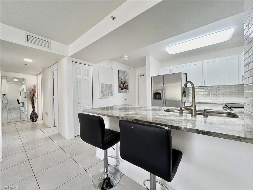 Kitchen featuring stainless steel fridge, white ca