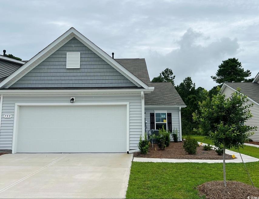 View of front of property featuring a front yard and a garage