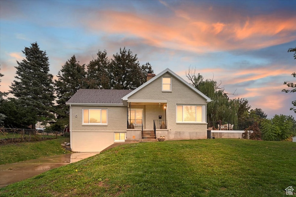 Bungalow-style home featuring a front yard, a chimney, brick siding, and a porch
