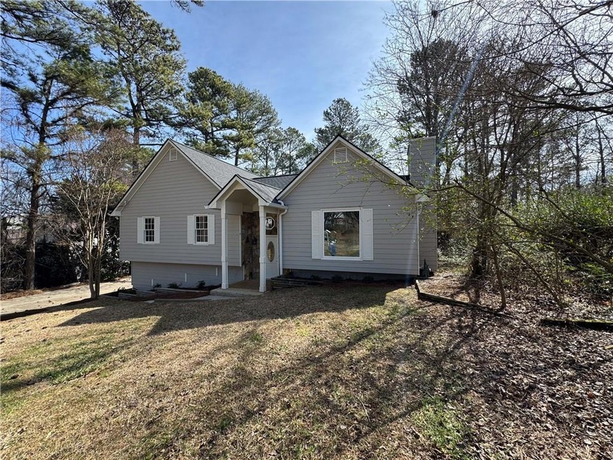 Ranch-style house with a chimney and a front yard