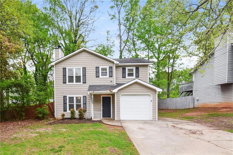 View of front of house with a front yard and a gar