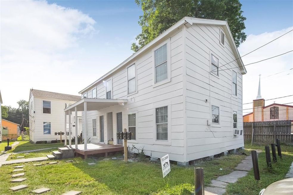 This photo shows a two-story white house with a sm